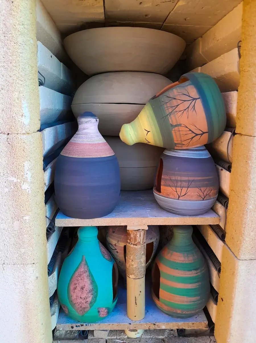 Glazed pots on a shelf in the studio