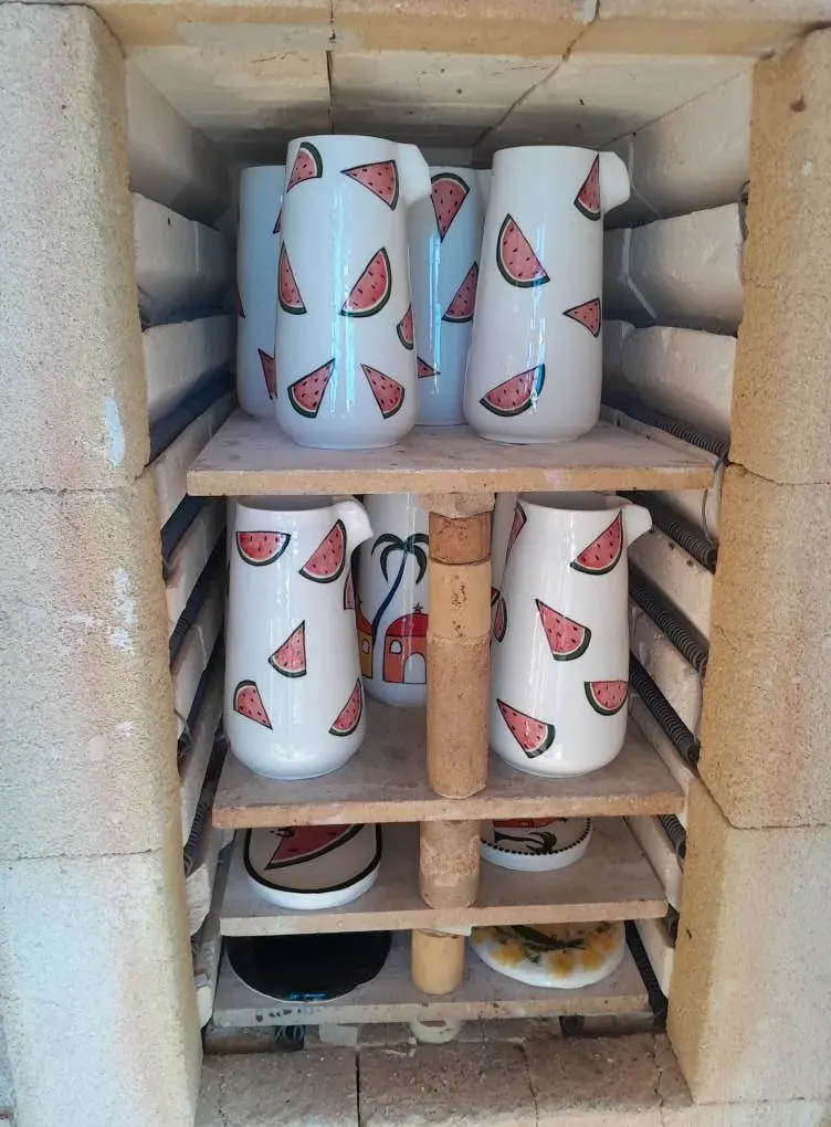 Painted mugs on a kiln shelf