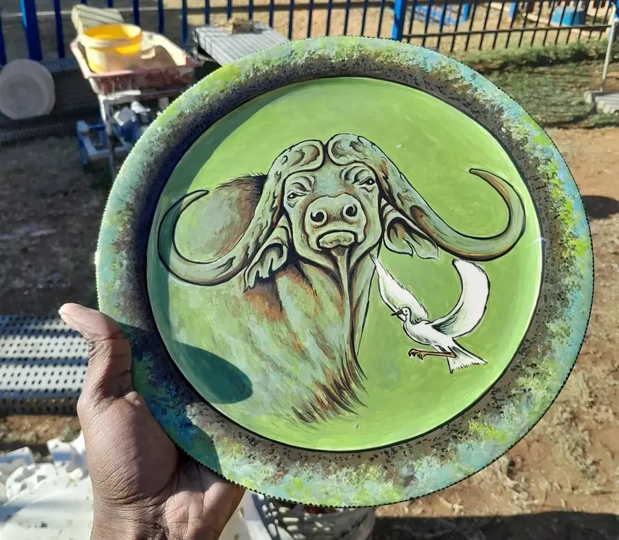 A green platter painted with a buffalo