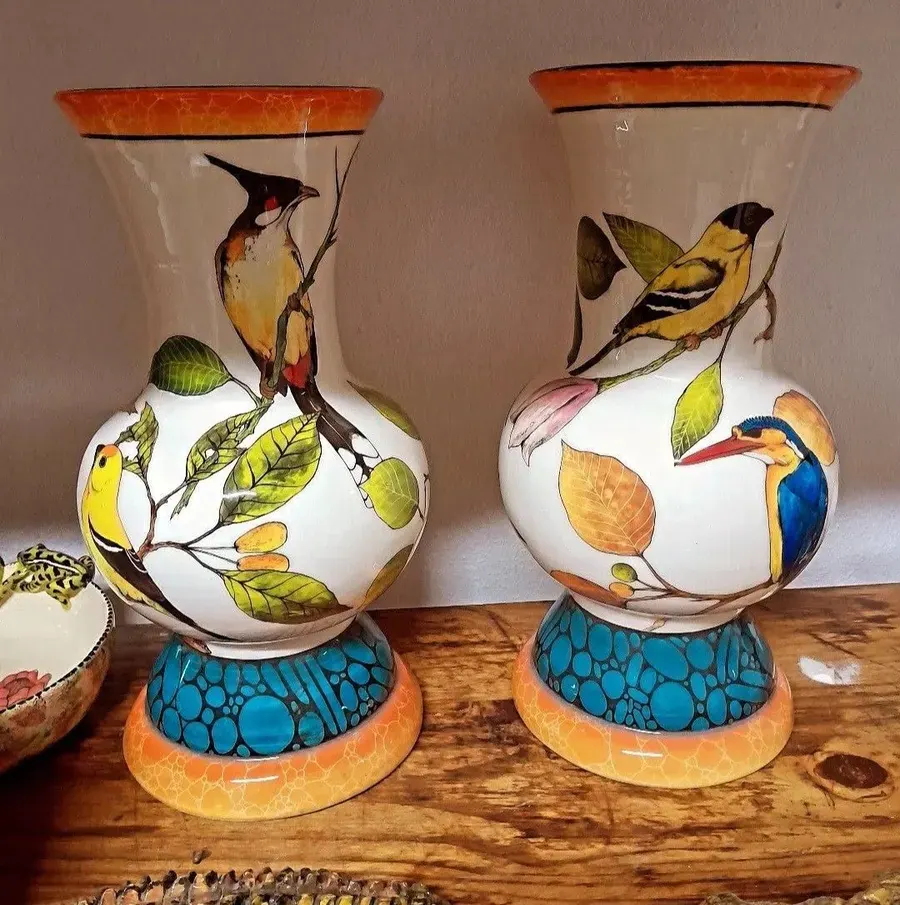 Two vases painted with birds on a shelf