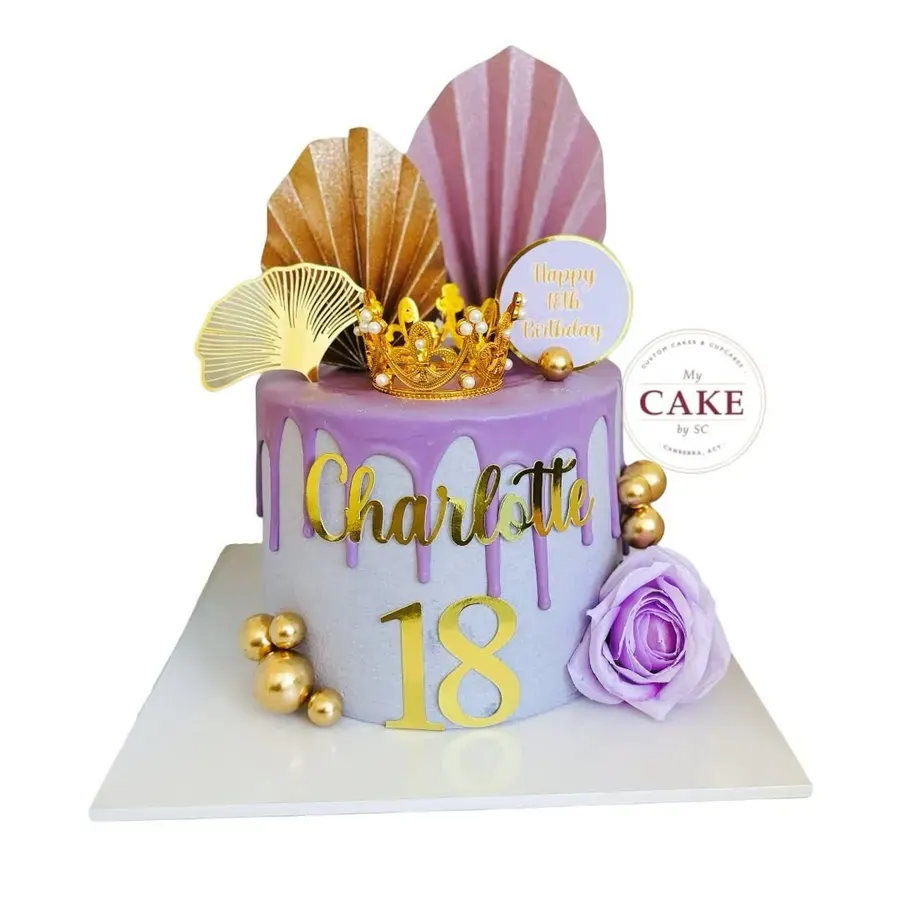 A lilac 18th birthday cake with gold shell toppers