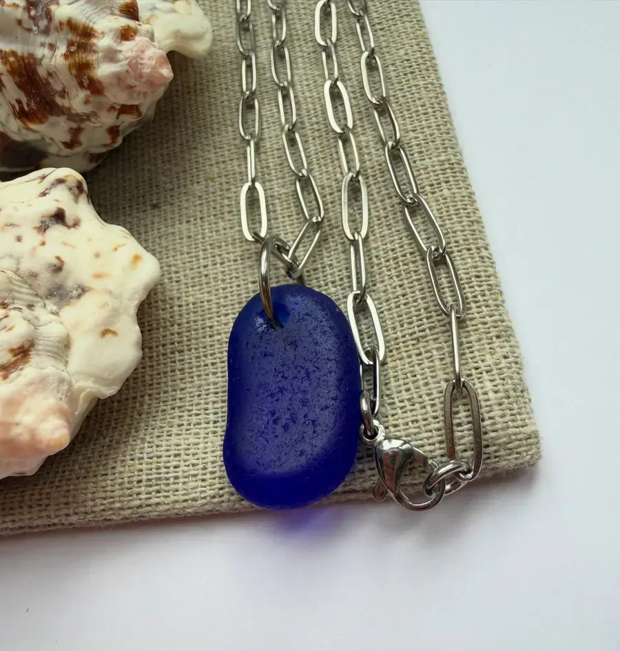 A blue sea glass pendant on a chain