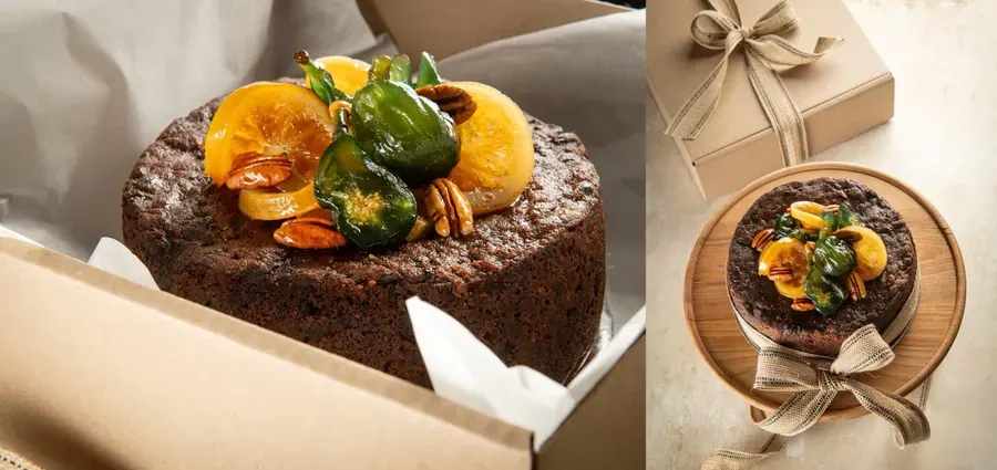 A fruit cake topped with nuts in a box