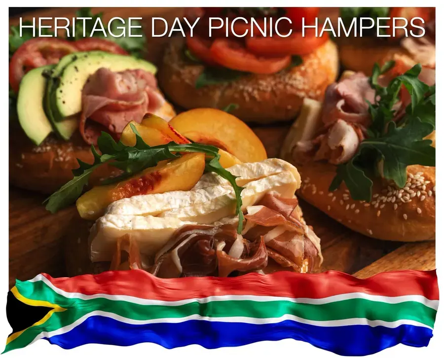 A picnic hamper with ham, bread and a South African flag