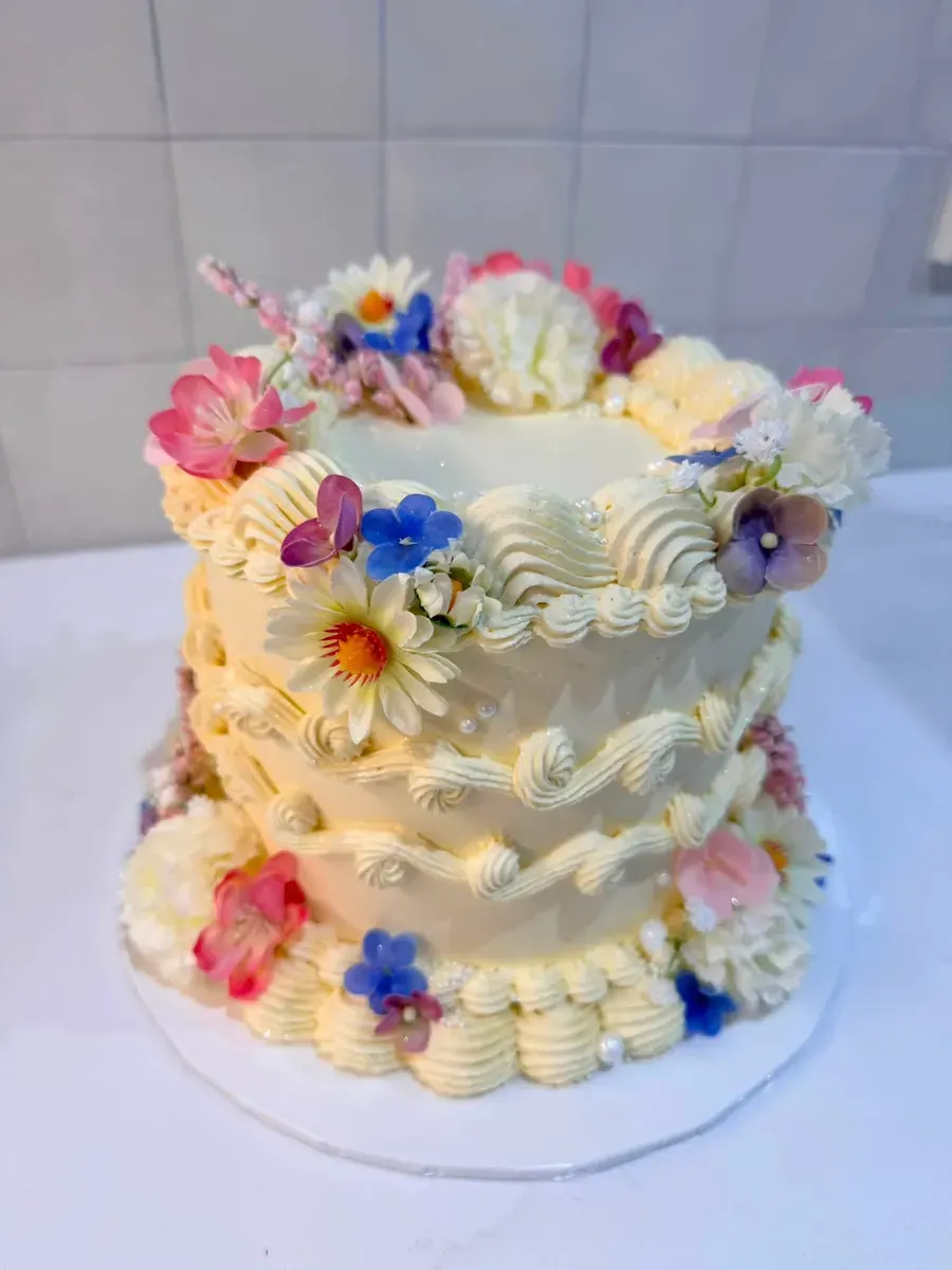 A buttercream cake covered in flowers