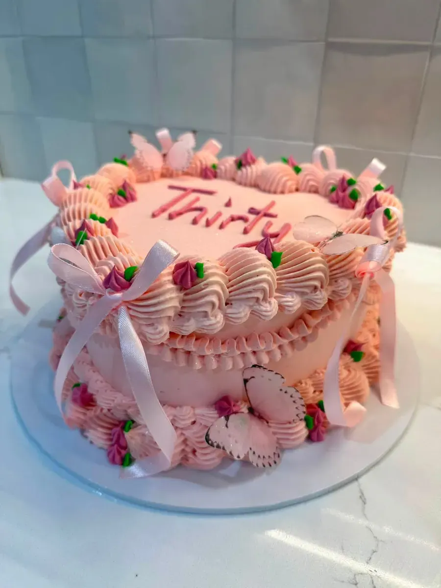 A pink cake with piped shells