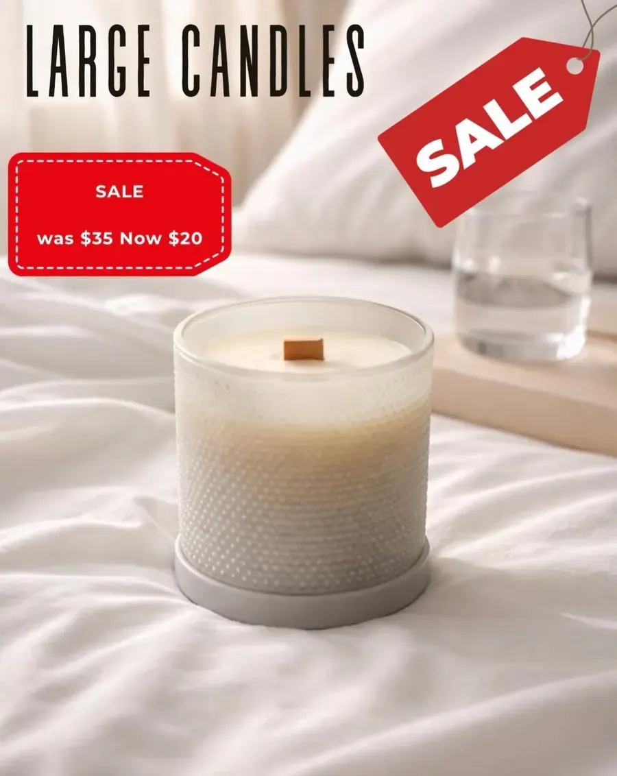 A wooden wick candle on a bed